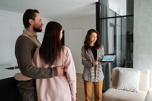 Bir emlakçı, ev gezisi sırasında bir çifte modern bir daireyi tanıtıyor.